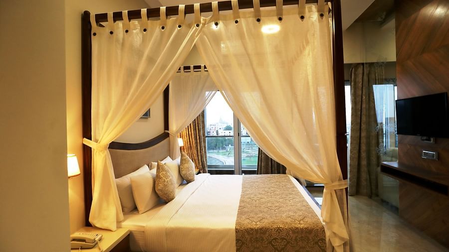 A close up shot of the king bed in the Suite Room with mosquito net covering the bedding - VITS Devbhumi, Dwarka