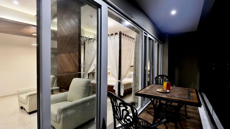 Overview of the balcony with chairs and a table on it inside the Suite Room - A bathtub inside the Suite bathroom with a commode next to it - VITS Devbhumi, Dwarka