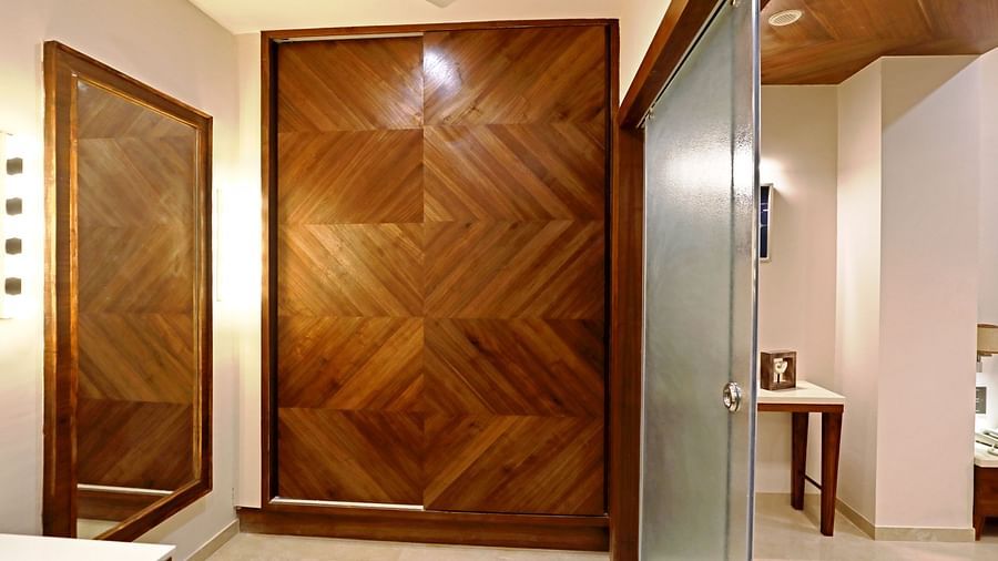The wardrobe area with a mirror and glass door inside the Suite - VITS Devbhumi, Dwarka