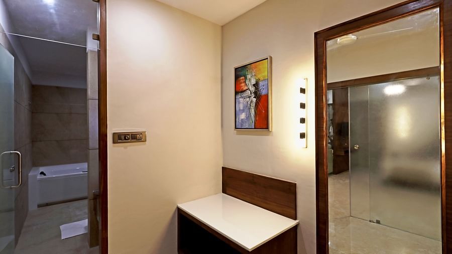 Overview of the bathroom inside the Suite with a mirror and a table next to it - VITS Devbhumi, Dwarka