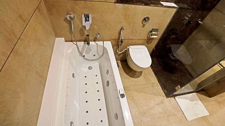 A bathtub inside the Suite bathroom with a commode next to it - VITS Devbhumi, Dwarka