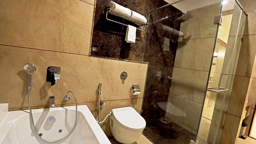 A bathtub inside the Suite bathroom with a commode next to it - VITS Devbhumi, Dwarka