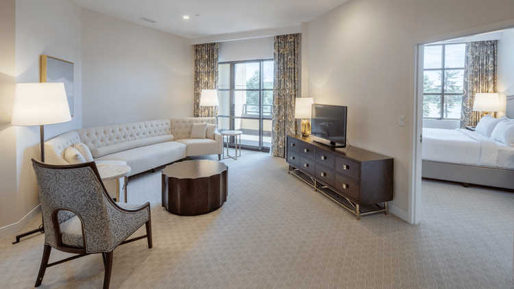 A large, well-decorated suite with a living area furnished with a white sofa and a separate bedroom visible through a doorway at YO1 Longevity & Health Resorts