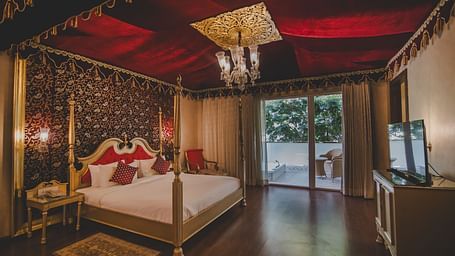 Image of a room with a bed and a chandelier above it at Rajasthali Resort & Spa Jaipur.
