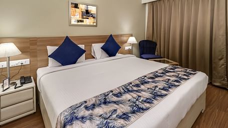 A double bed with side tables inside Deluxe Suite - Starlit Suites Newtown, Kolkata