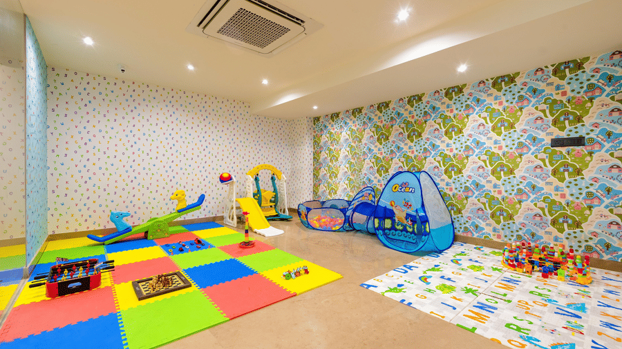 A colourful mat along with a small slide and various other toys at the indoor kids' play area at Hotel 91 Privé, Gurugram.