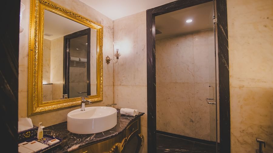 Image of a washroom with a mirror and a sink below it at Rajasthali Resort & Spa Jaipur..