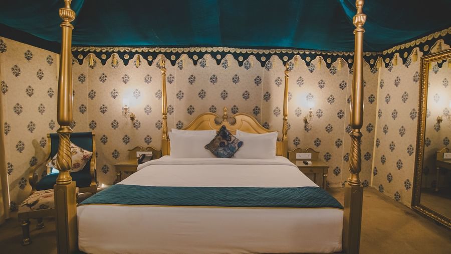 Front view of Royal Luxury Tent with Balcony with a bed that has a metal frame at Rajasthali Resort and Spa.