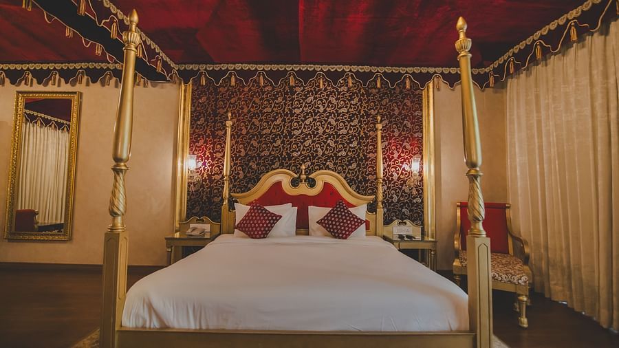 Image of a room with a bed and a mirror on the side at Rajasthali Resort & Spa Jaipur.