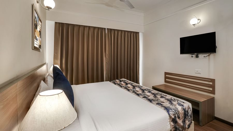 A double bed with a tv opposite it inside Premium Studio - Starlit Suites Newtown, Kolkata