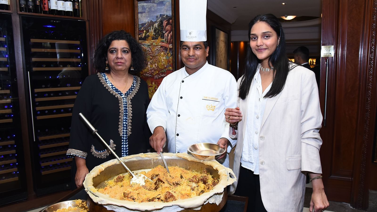 Chef Asma with other two individuals behind a pot of biryani at the The Claridges New Delhi - Claridges Collection
