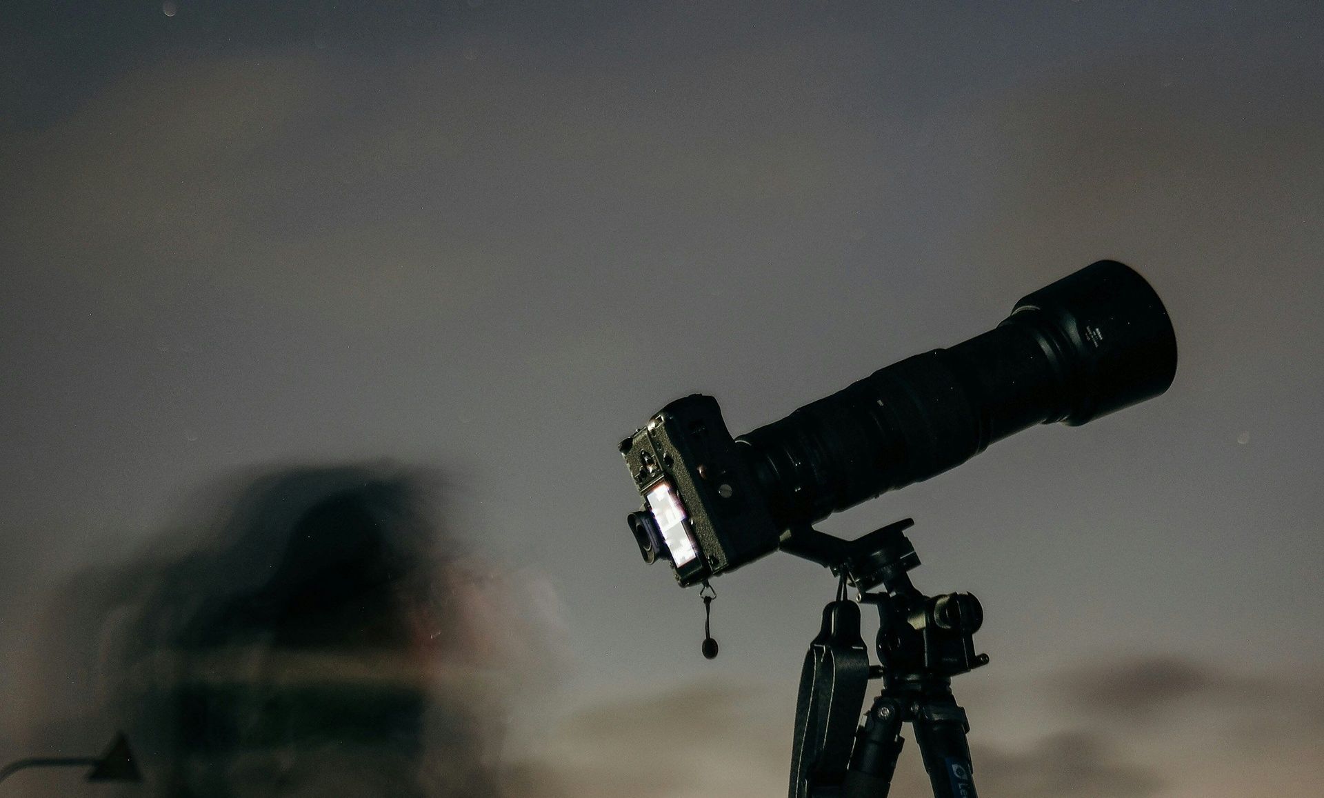 Camera on tripod under a night sky.