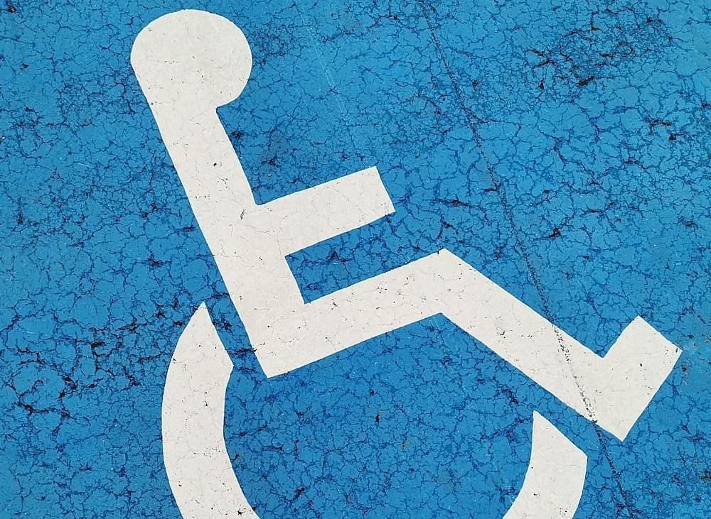A parking space with a wheelchair symbol, indicating accessibility for people with disabilities.