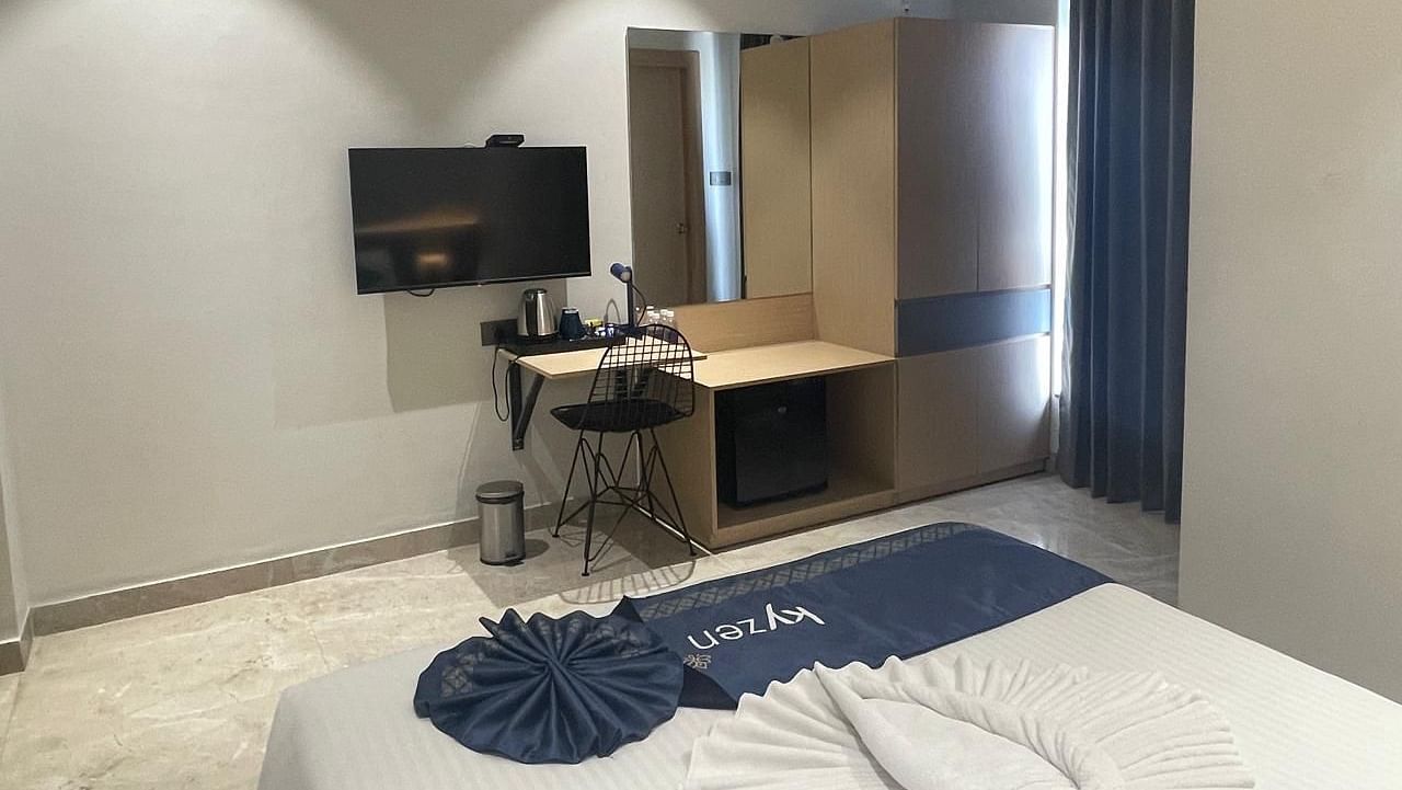 Contemporary suite with a wall-mounted TV, desk, and ample natural light at Hotel Kyzen HiTech City – Your Zenly Stay