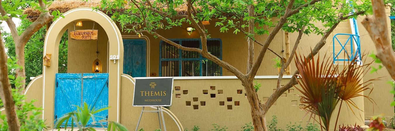 exterior of luxurious suite surrounded by lush greenery at Themis Mudhouse - A Nature's Retreat Resort & Wellness