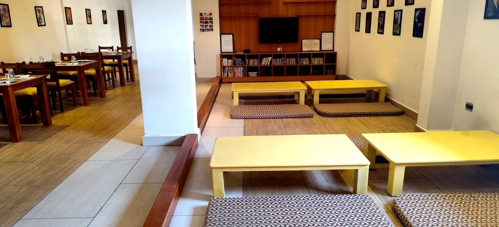 Seating arrangement on the floor at Ajito restaurant with pale yellow coloured tables surrounded with cushioned mattresses at Ilara Hotels & Spa, Tada.