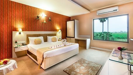 A view of a king size bed with a window and AC of a room at Regency Tuticorin by GRT Hotels
