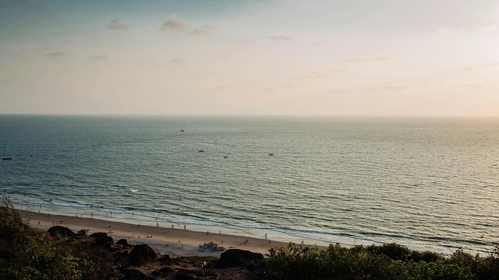 A tranquil seascape view from an elevated point, showing a vast expanse of water meeting a distant horizon under a calm sky.