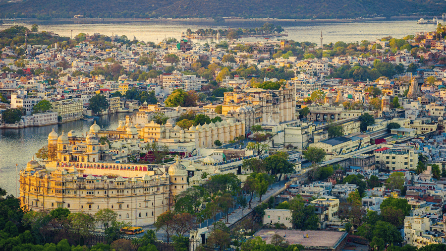 Aerial view of the city of Udaipur with the City Palace in the foreground and Lake Pichola in the backdrop.