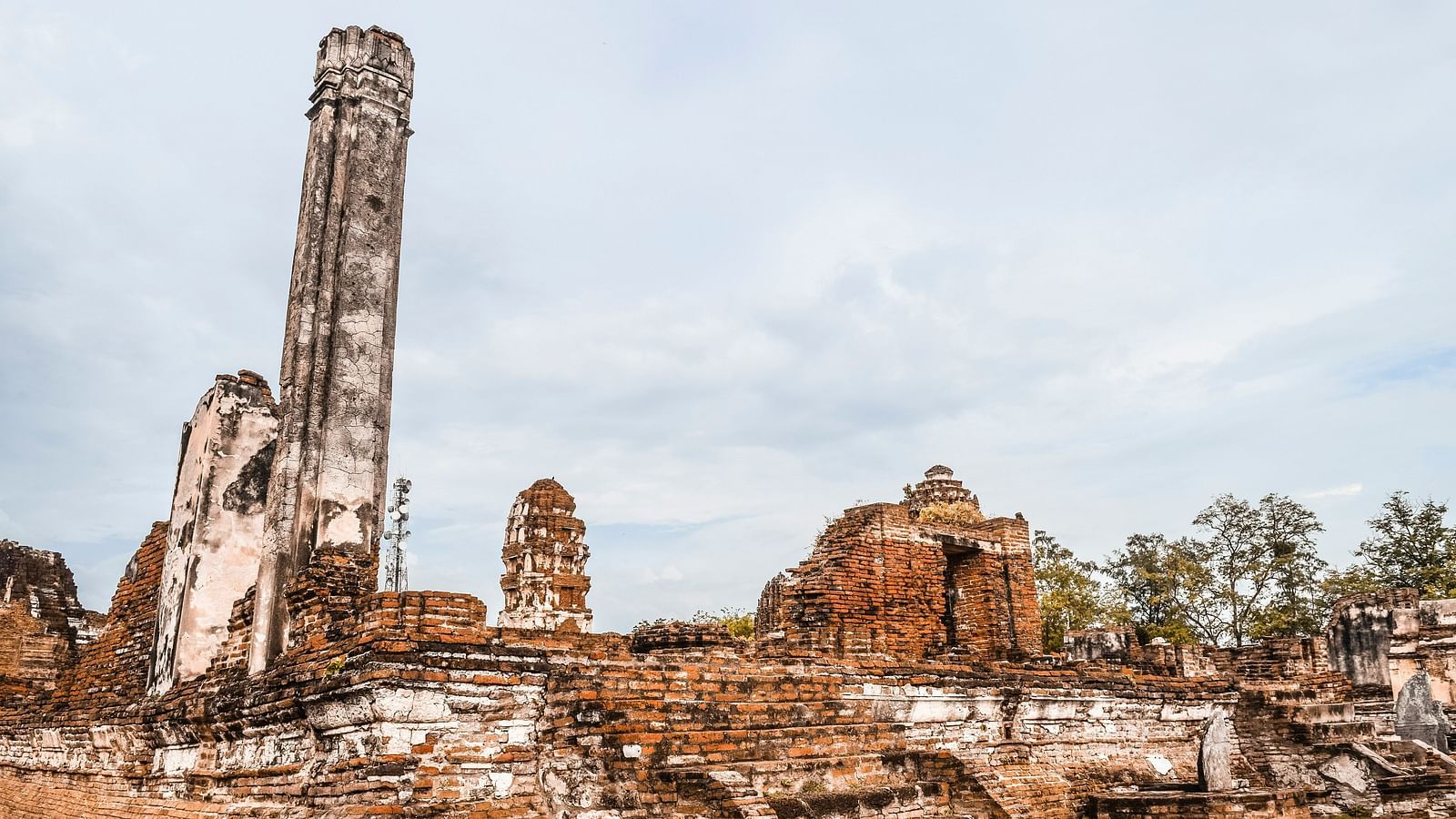 An overview of the ruins of Ayutthaya with trees in the background.