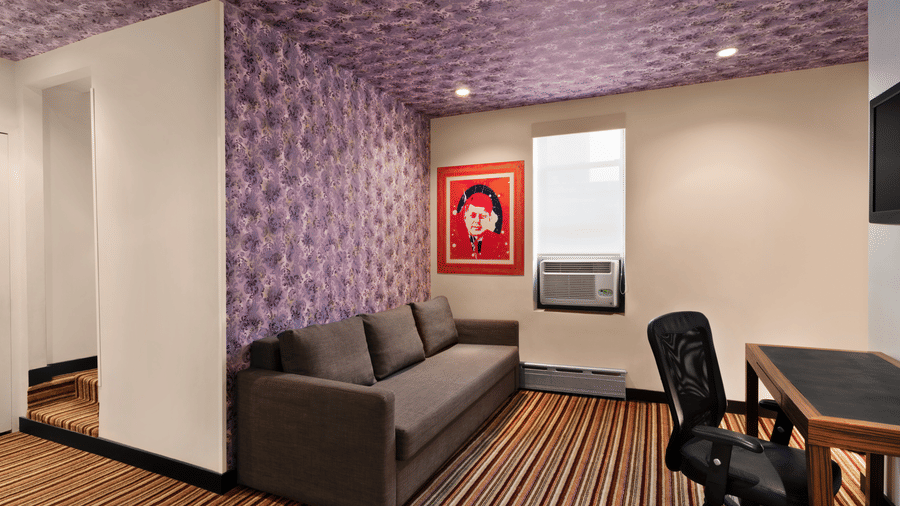 Suite at Night Hotel Broadway with a sofa, work desk, and ample open floor space.