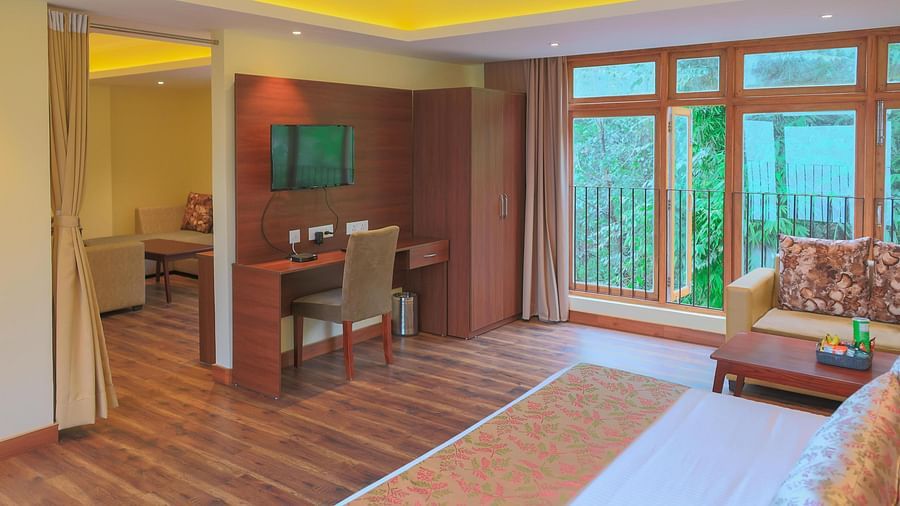the Junior Suite with wooden flooring a huge window in the far end of the room at Yashshree Karbari Resort & Spa, Yangang