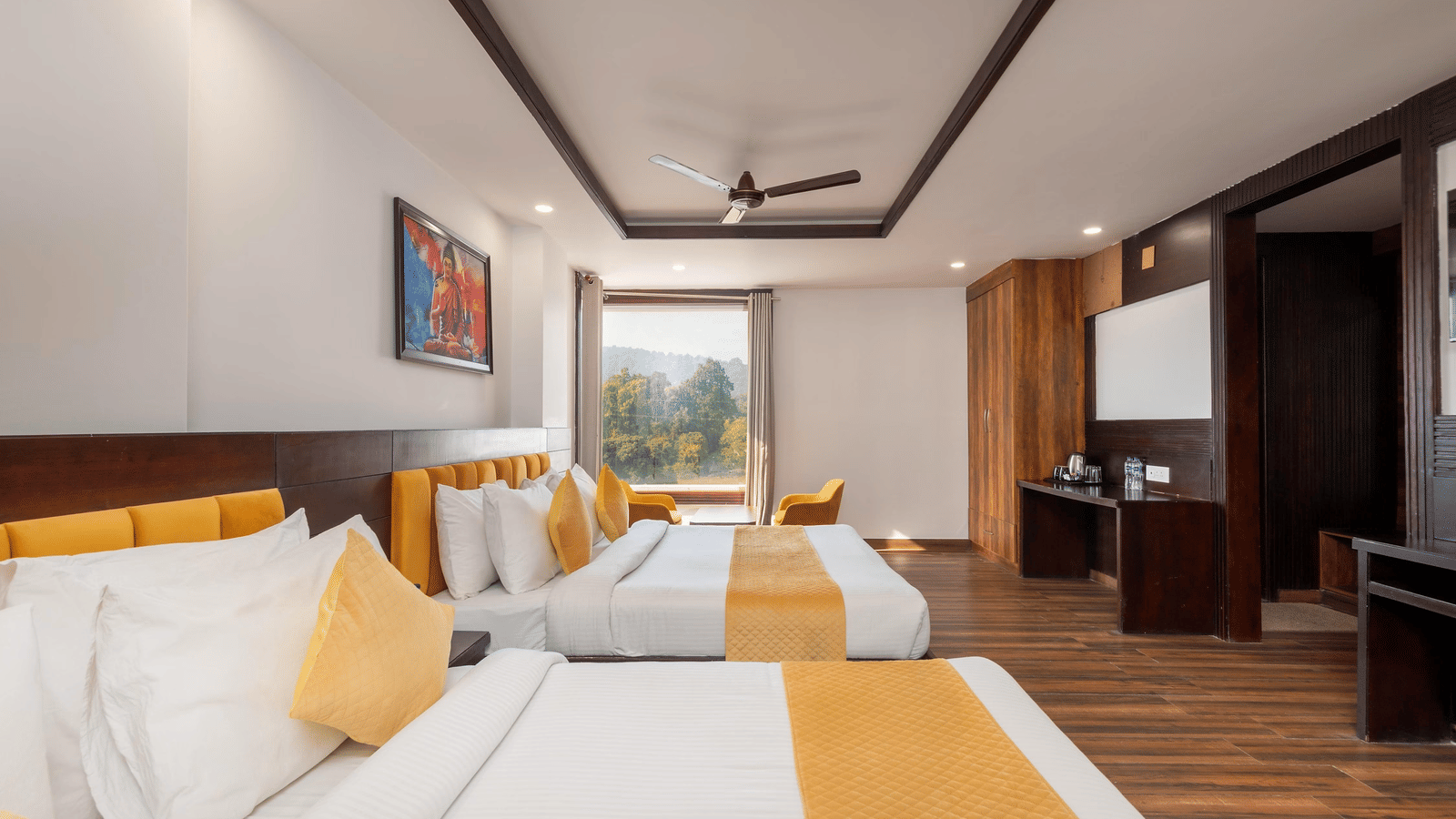 Interior of a room with 2 beds, a television, wardrobe area, and a window with outside view at Perfectstayz Premium Shanti Heritage, Haridwar.