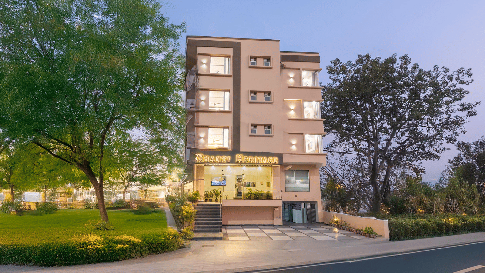 Facade of Perfectstayz Premium Shanti Heritage, Haridwar with trees surrounding the hotel.
