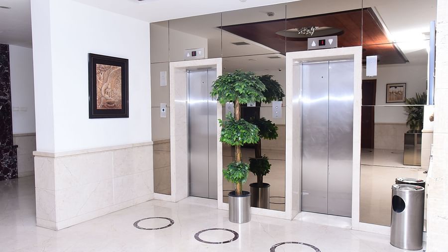 A sleek and modern lift lobby with stainless steel elevators.- Dhanalakshmi Srinivasan Hotels, Perambalur