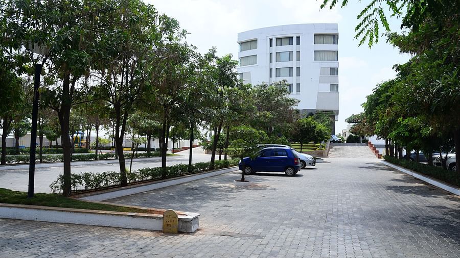 A tree-lined driveway leading to the hotel, creating a serene and inviting atmosphere for visitors.- Dhanalakshmi Srinivasan Hotels, Perambalur
