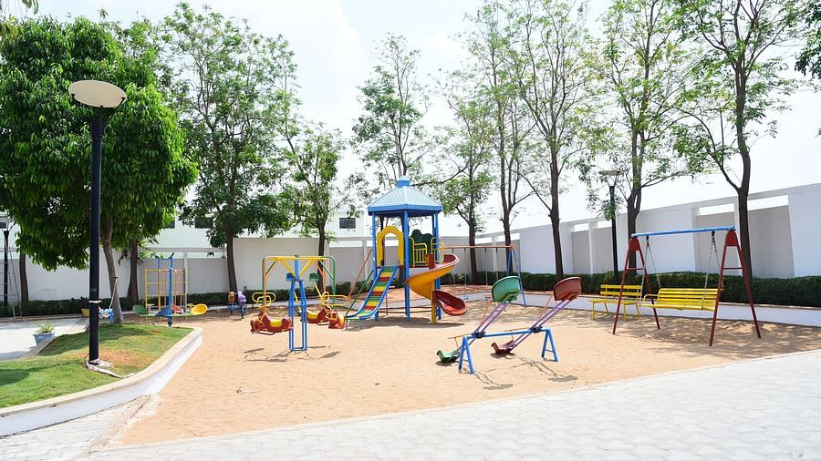 A well-maintained children's playground with swings and slides, providing a fun outdoor space.- Dhanalakshmi Srinivasan Hotels, Perambalur