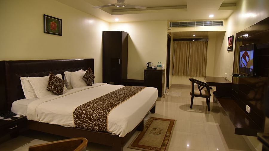 Superior Room with bed and a television in front at Hotel Green Apple