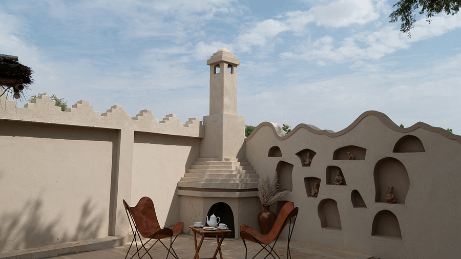 An image of an outdoor sit out area it two chairs and a table in a terrace