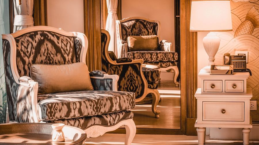 image of a patterned cushioned armchair with a mirror behind it - one bedroom private pool beachfront villa