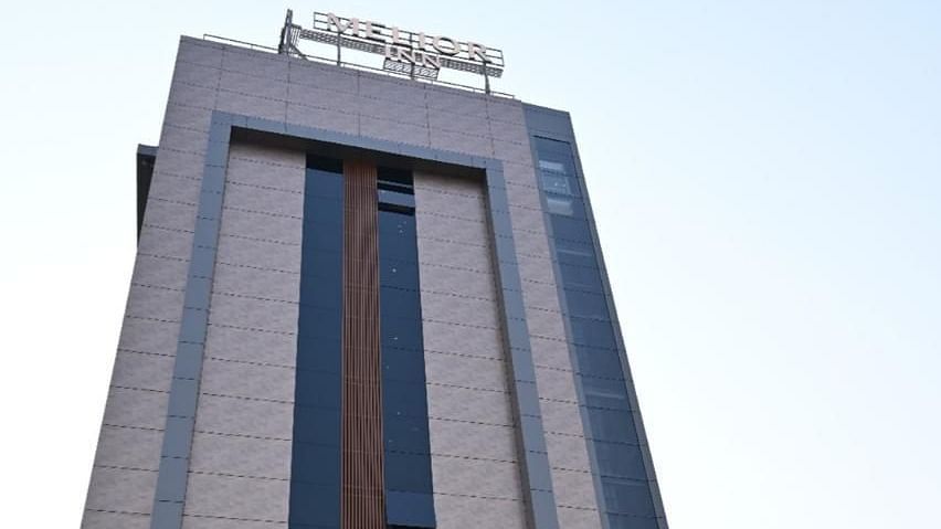 The tall building of Melior Inn is depicted against a clear sky.