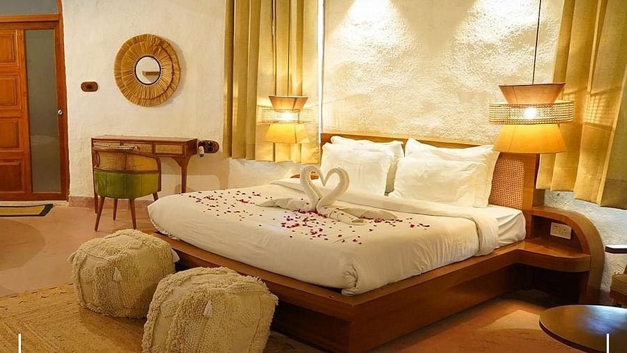 A side angle view of a cozy room at Themis Mudhouse, featuring a king-size bed and a warm, inviting atmosphere.