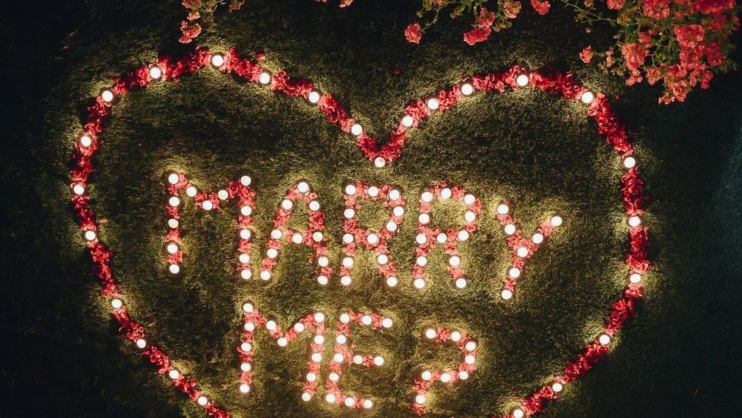 Marry Me light-up sign placed in the garden, creating a romantic proposal setting at Karma Chalets.