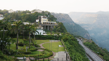 A scenic aerial view of Athiva Hotels & Resorts set along a hillside with winding roads and expansive valley views.