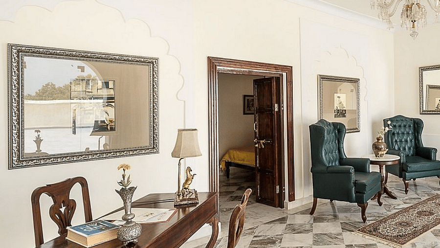 A well-lit room at Fort Barli, featuring a polished wooden desk, checkered marble floor, and elegant seating, showcases the fort's refined interior.