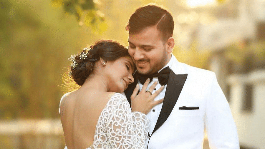 Bride and groom dressed in white embraces each other