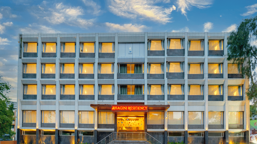 The illuminated exterior facade, lit windows, and entrance of Icon Express By Bhagini, Mahadevapura under an evening sky.