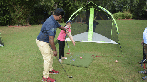 Heritage Village Resorts Manesar - image of a golf instructor teaching a child about the sport
