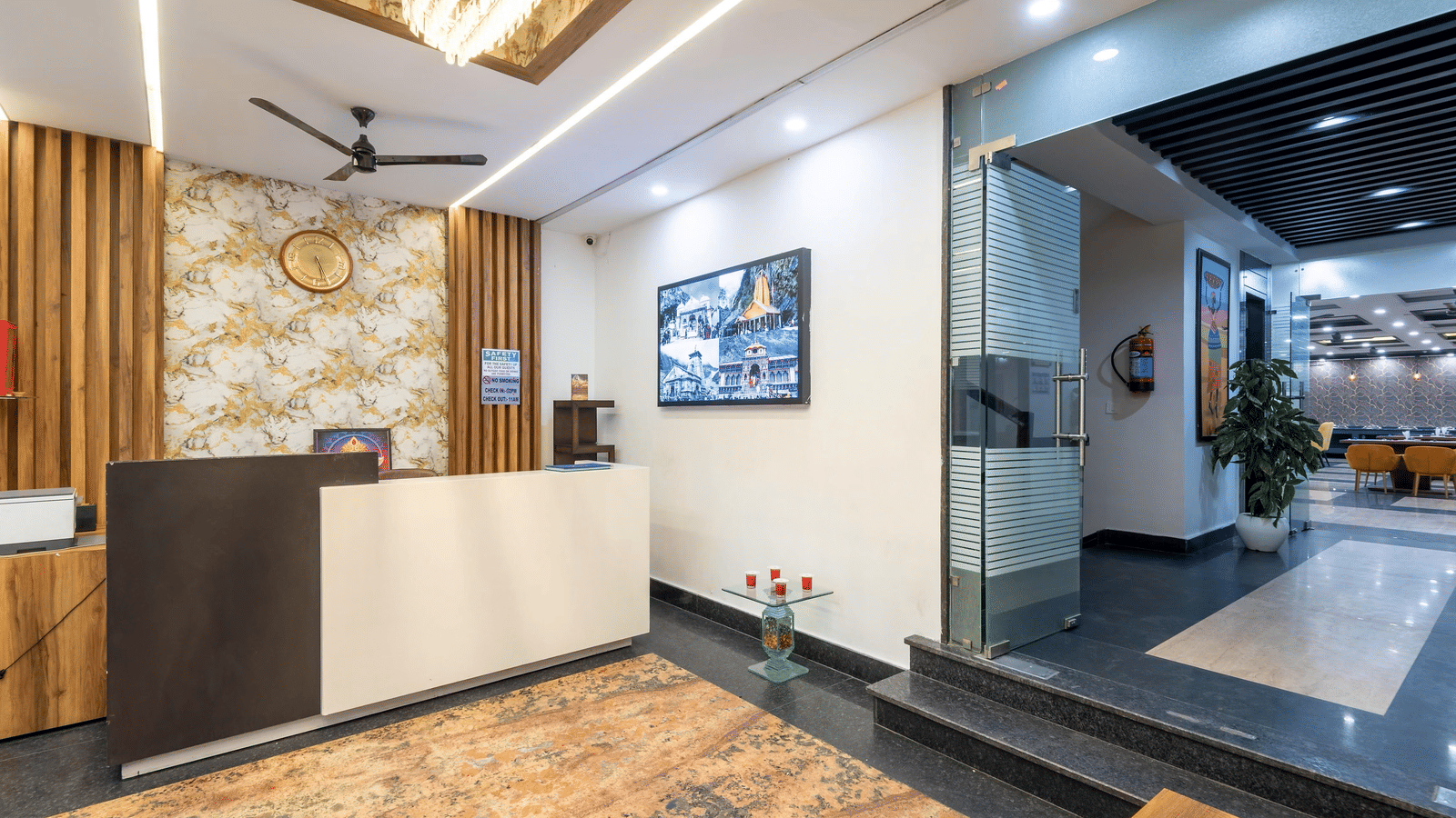 Lobby area with front desk, television, and hallway visible on the side at Perfectstayz Premium Shanti Heritage, Haridwar.