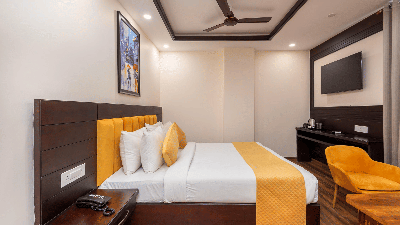 Hotel room with 2 large beds, bedside tables, wall mounted television, and a framed artwork at Perfectstayz Premium Shanti Heritage, Haridwar