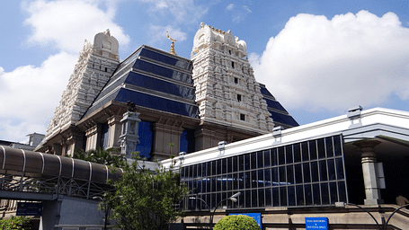 An overview of ISKCON temple in Indore with white clouds on blue sky in the background.