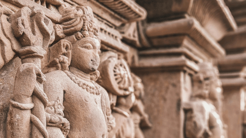 A detailed sculpture carved into the stone of a temple, showcasing intricate designs and ornate patterns.