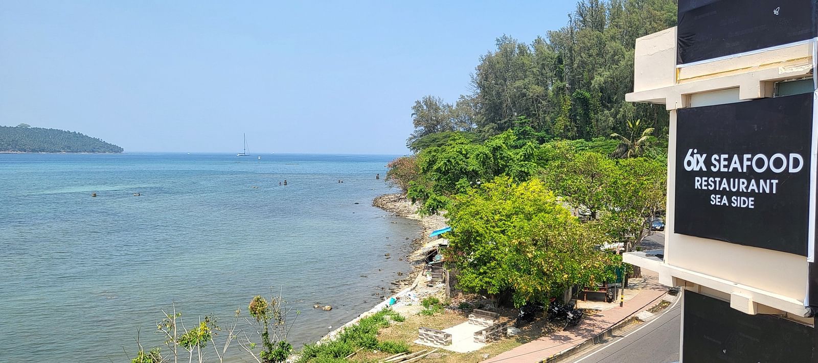 View of the ocean outside 6ix Seashore Hotel, Port Blair along with trees on the shore