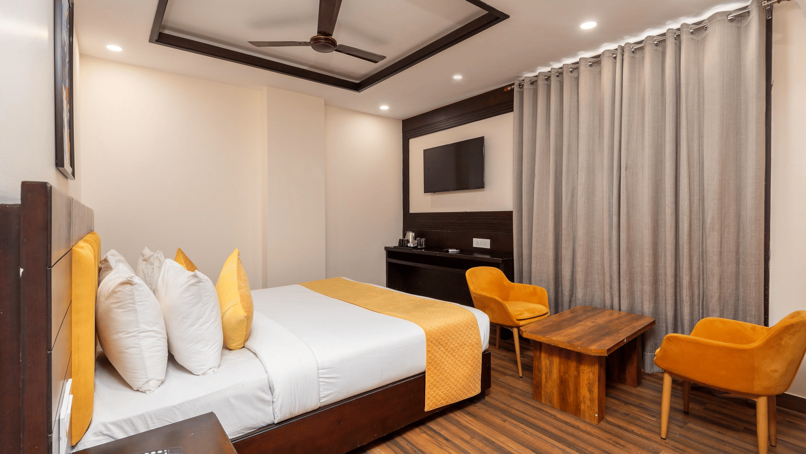 Hotel room with 2 large beds, a television, ceiling fan, and a wall artwork at Perfectstayz Premium Shanti Heritage, Haridwar
