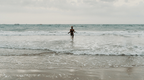 a person standing amidst waves during workation in goa for a month