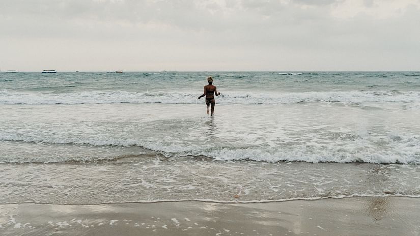 a person standing amidst waves during workation in goa for a month